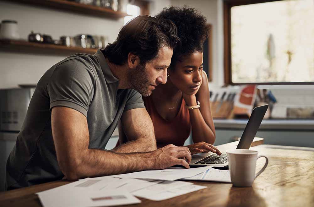 Couple at home looking at a laptop