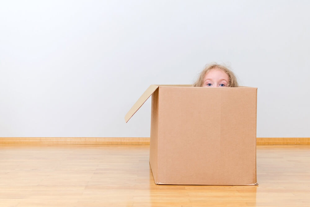 Child peeking out of moving box