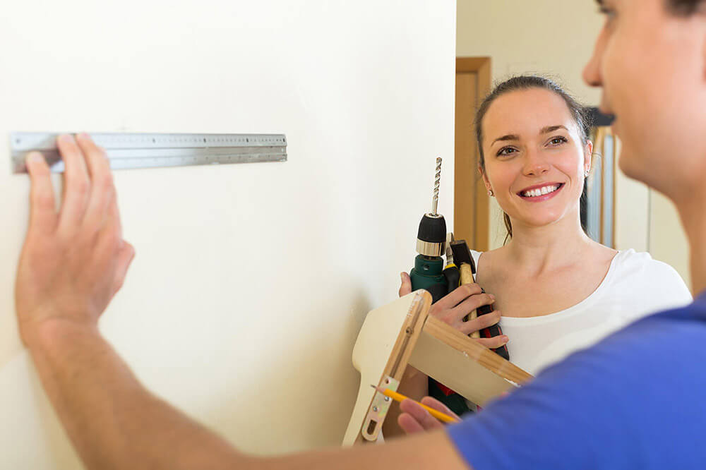 Couple hanging a shelf