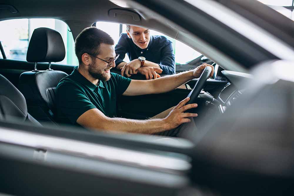 Young man testing a car at a showroom
