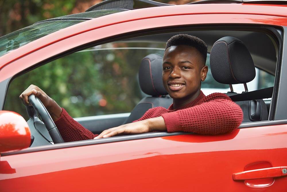 Teenage boy driving car