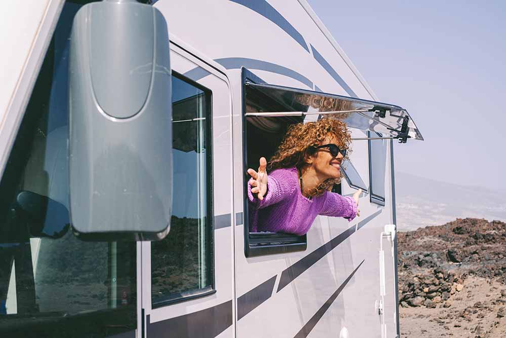 Woman stretching out the window of an RV
