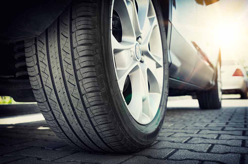 A close-up of a parked car's tire