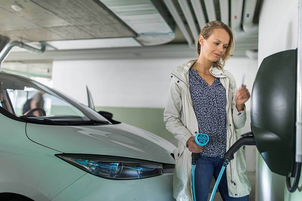 Woman charging an electric vehicle