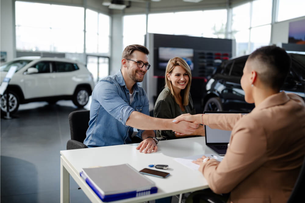 Smiling couple buying a car and car insurance with Sonnet