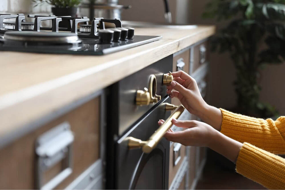 Person’s hands using buttons on the stove