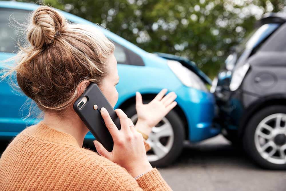 Woman on the phone with her insurance provider after an auto accident