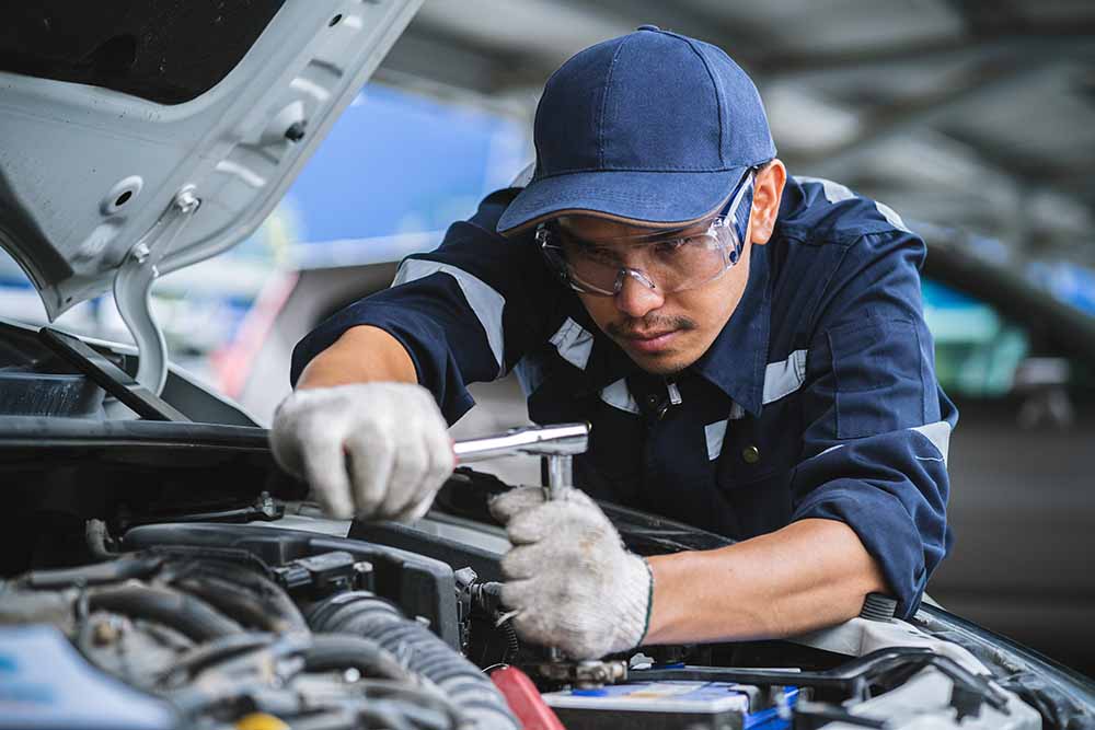 Mechanic working inside a car hood