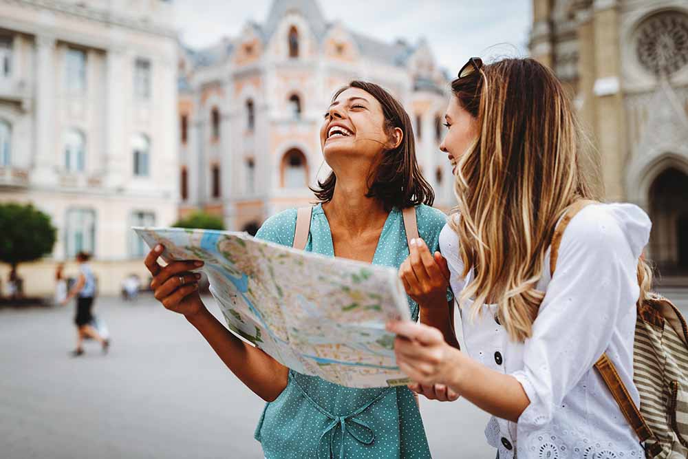Deux jeunes femmes consultent une carte dans une ville européenne