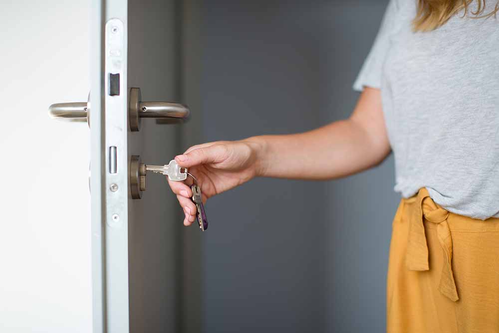 Femme barrant la porte d’une maison