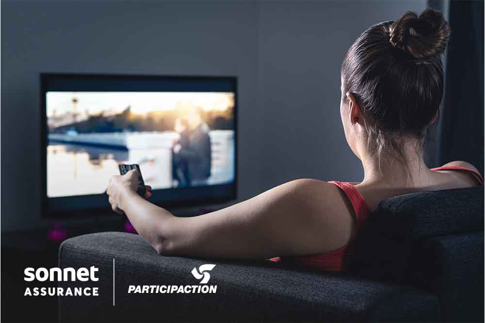 Une femme assise regarde la télévision