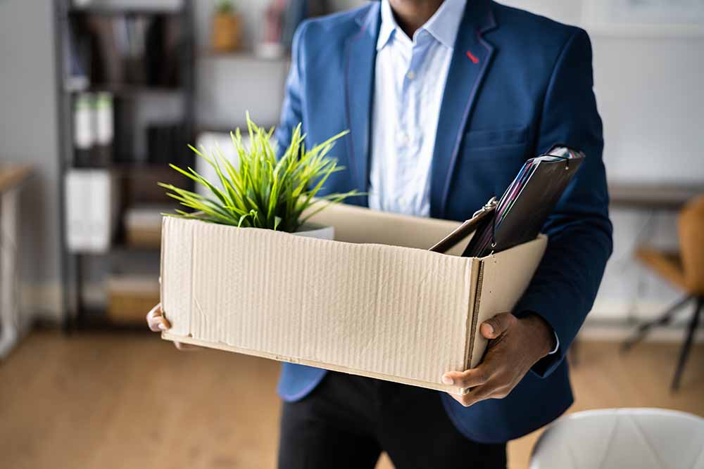 Employee leaving an office with a box full of items