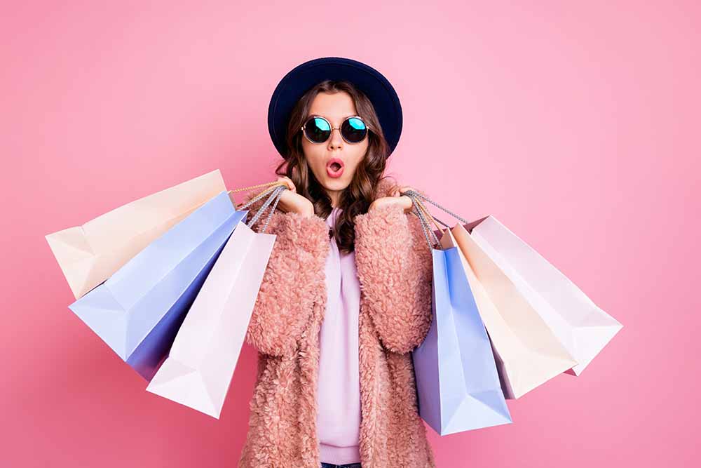 Young woman carrying many shopping bags