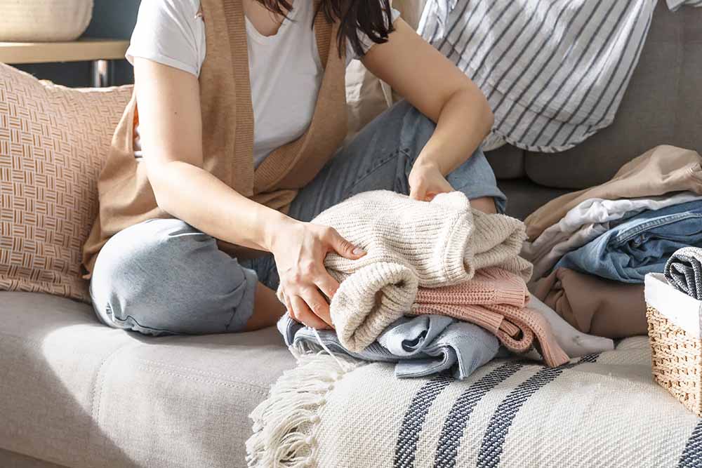 Young woman folding clothes