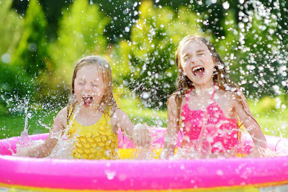Two girls splashing in blow up pool