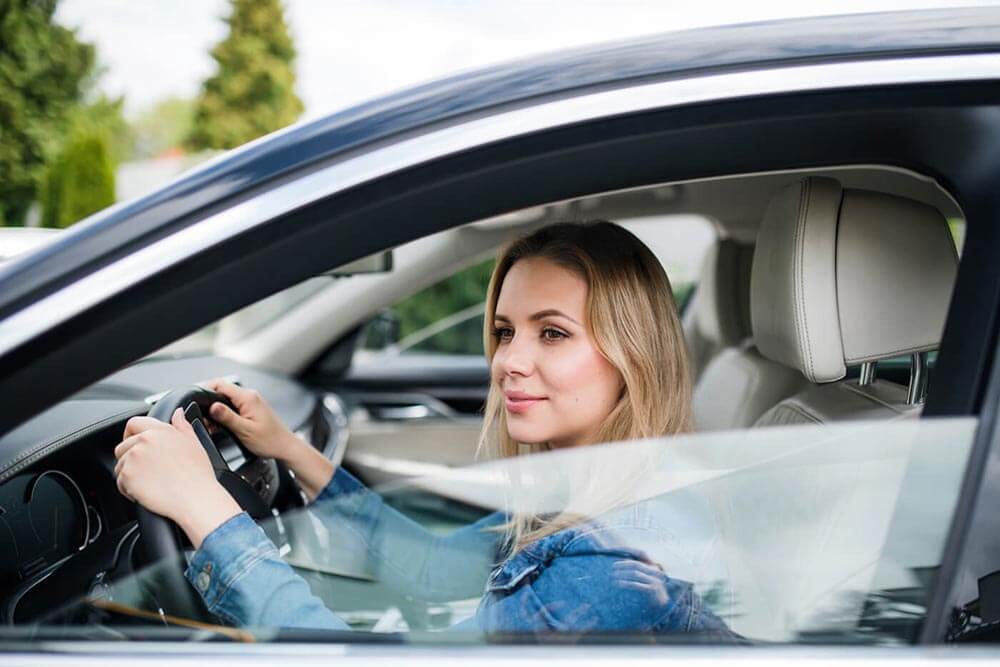 Woman sitting in car driver's seat