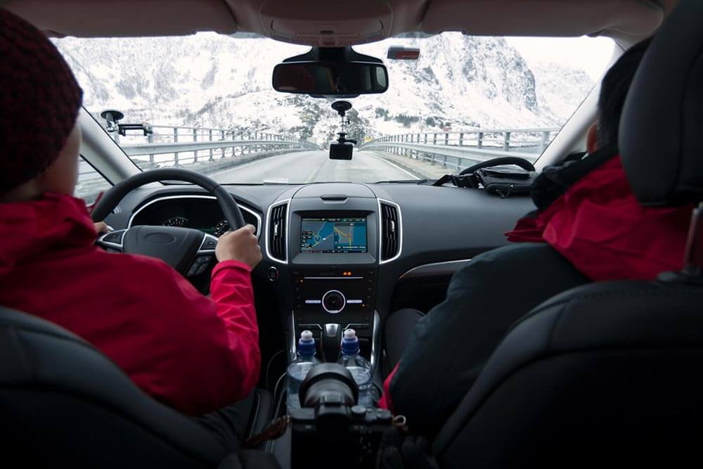 Couple dans une voiture qui se promène dans les montagnes