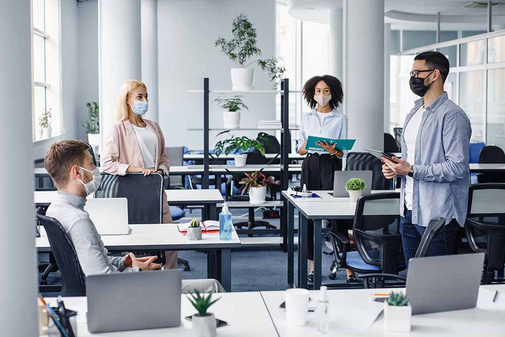 Groupe d’employés de bureau portant un masque