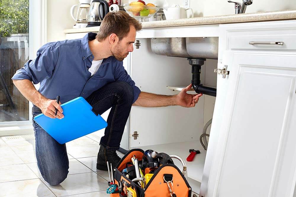 Man inspecting home plumbing
